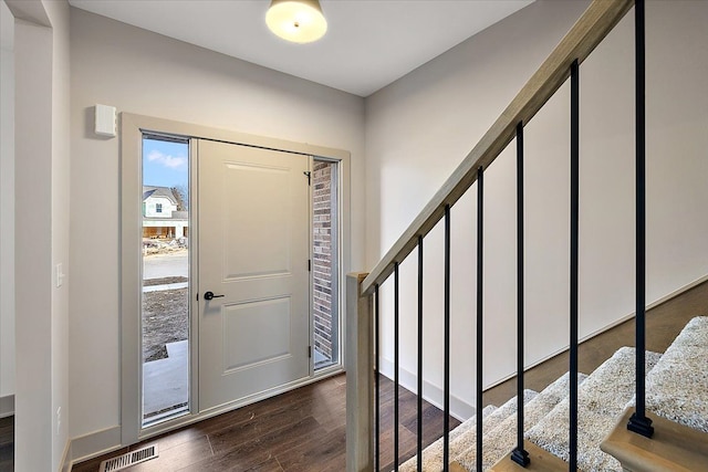 foyer entrance featuring baseboards, stairs, visible vents, and dark wood-type flooring