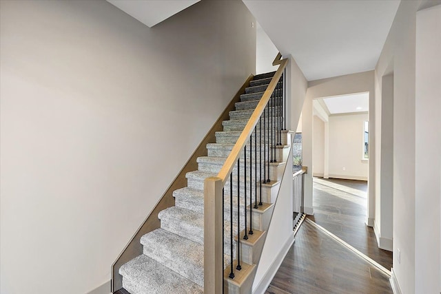 stairway with baseboards and wood finished floors