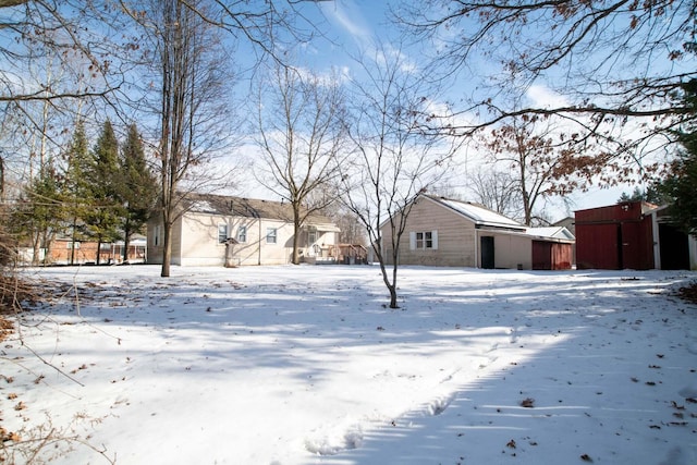 yard covered in snow with an outbuilding