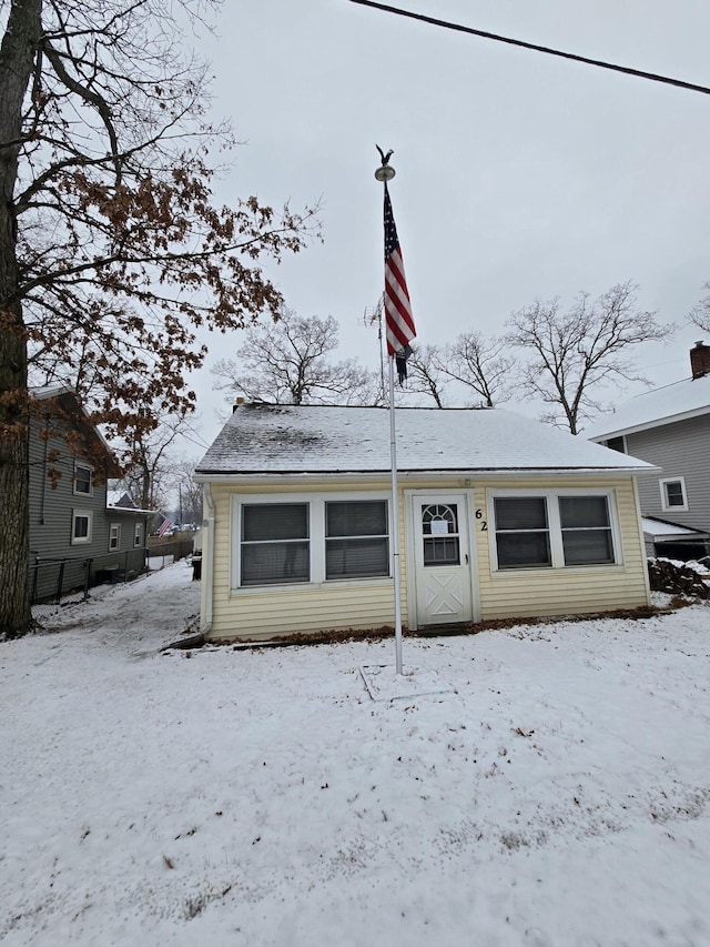 snow covered rear of property with fence