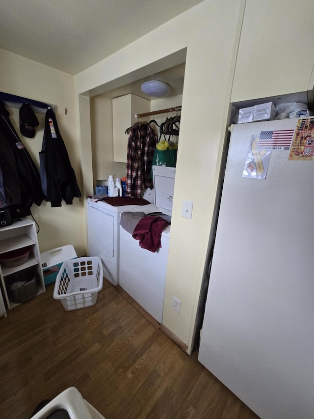 clothes washing area with washer and clothes dryer and wood finished floors