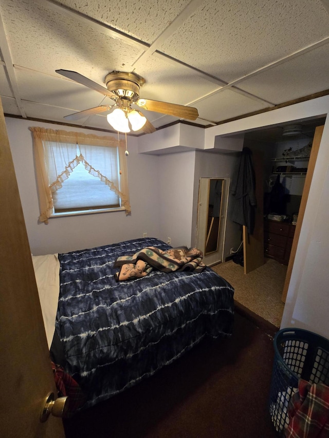 bedroom featuring carpet floors, a paneled ceiling, and a ceiling fan