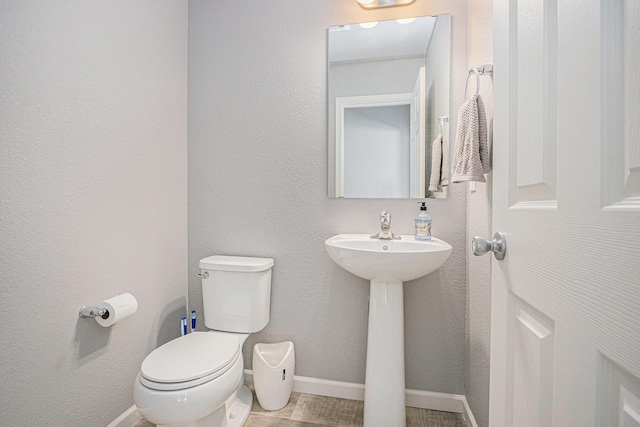 bathroom featuring baseboards and toilet