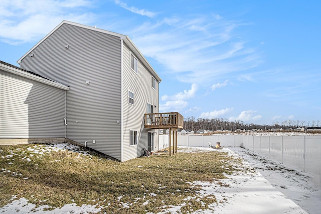 snow covered property featuring a fenced backyard and a wooden deck