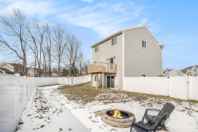 snow covered property with a fire pit and a fenced backyard