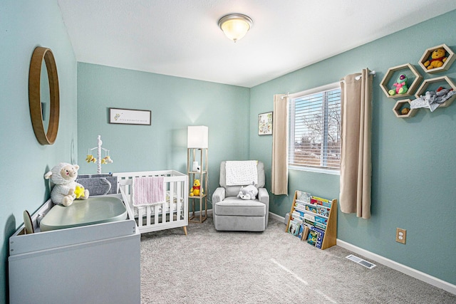 bedroom featuring a nursery area, carpet floors, visible vents, and baseboards