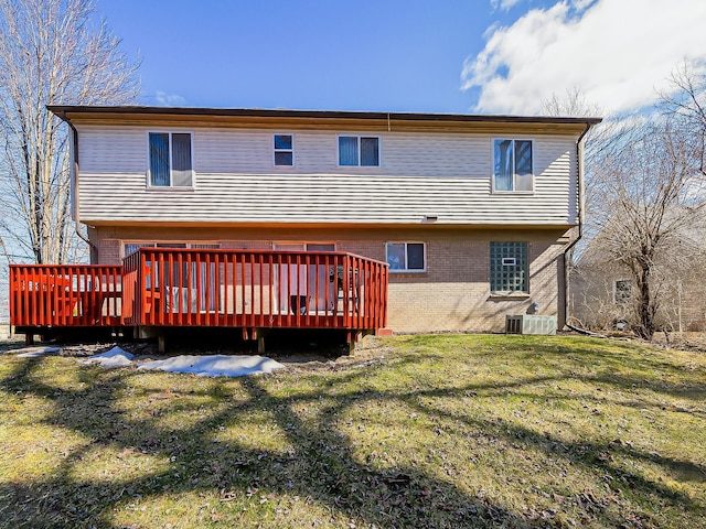 rear view of house with brick siding, a yard, a wooden deck, and central air condition unit