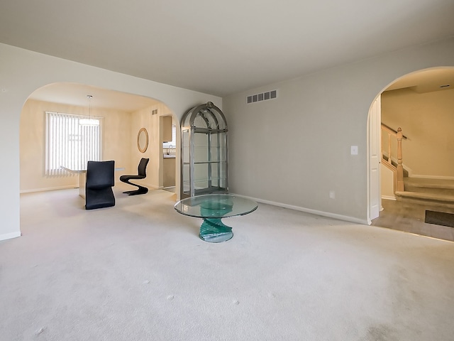 sitting room with visible vents, arched walkways, baseboards, stairway, and carpet flooring