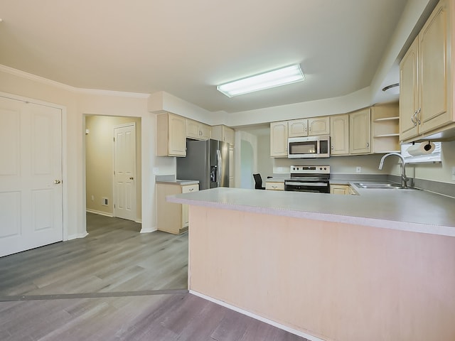 kitchen featuring light wood finished floors, open shelves, appliances with stainless steel finishes, a sink, and a peninsula