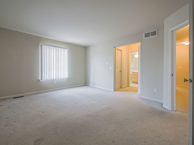 carpeted spare room with baseboards and visible vents