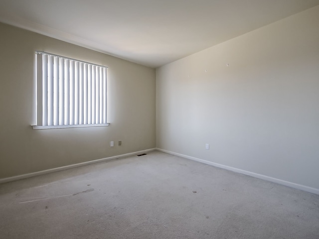 unfurnished room featuring visible vents, baseboards, and carpet flooring