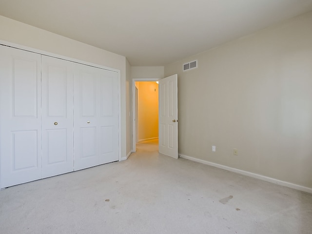 unfurnished bedroom with a closet, visible vents, and baseboards