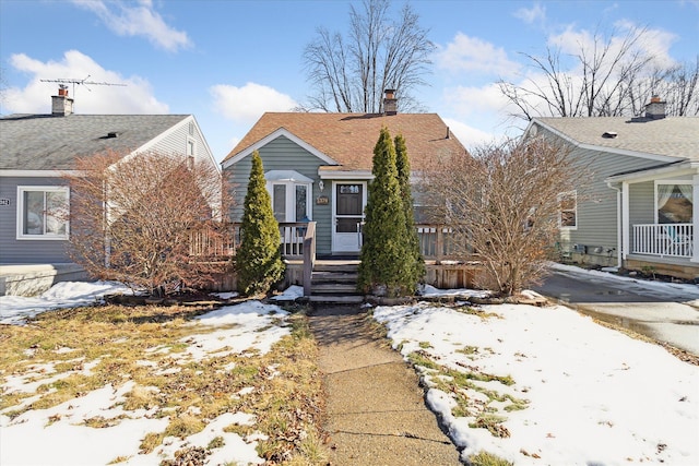 bungalow-style home with roof with shingles