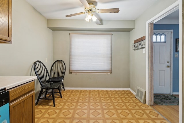 sitting room with parquet floors, baseboards, visible vents, and a ceiling fan