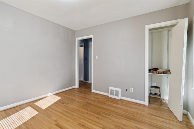 unfurnished bedroom with light wood finished floors, visible vents, and baseboards