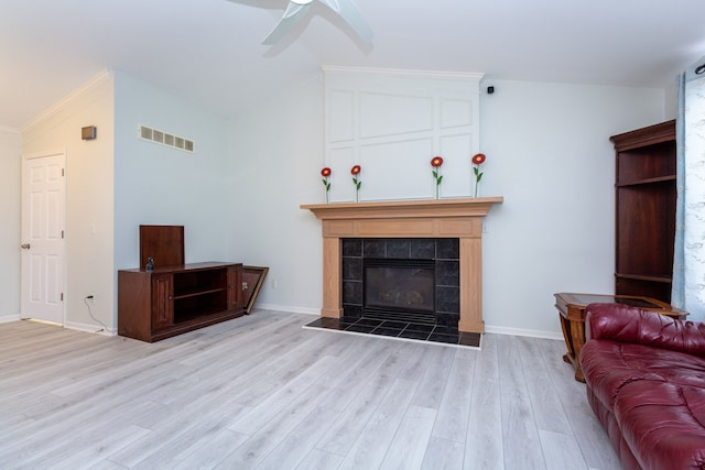 living room with lofted ceiling, a fireplace, wood finished floors, and visible vents