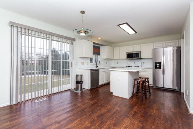 kitchen featuring dark wood finished floors, light countertops, appliances with stainless steel finishes, white cabinets, and a sink