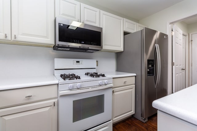 kitchen featuring light countertops, appliances with stainless steel finishes, dark wood finished floors, and white cabinets