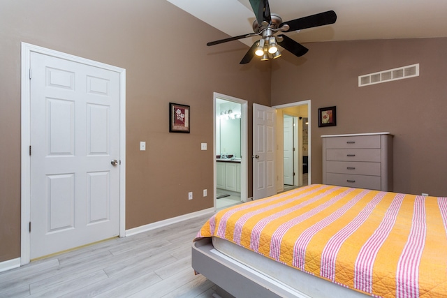 bedroom featuring baseboards, visible vents, connected bathroom, lofted ceiling, and light wood-style floors