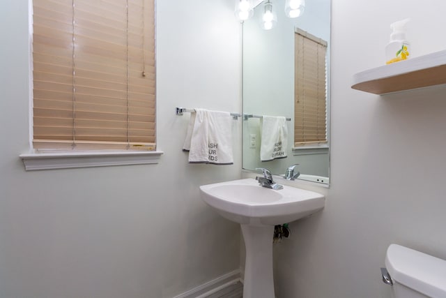 bathroom featuring baseboards and toilet