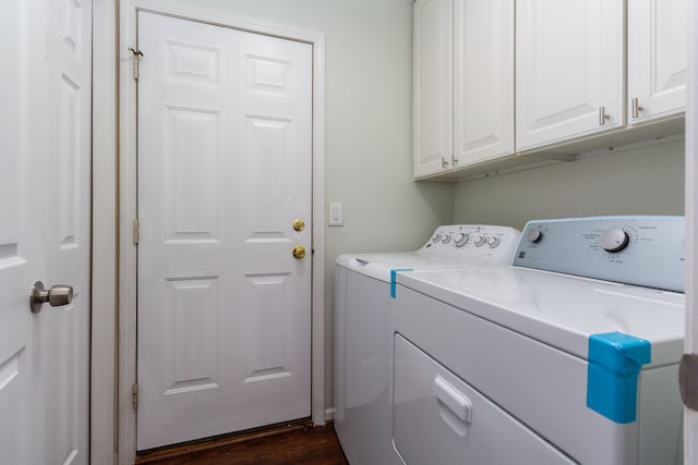 washroom featuring cabinet space, washer and clothes dryer, and dark wood-style flooring