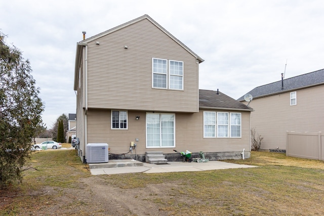 back of house with entry steps, cooling unit, fence, a yard, and a patio area