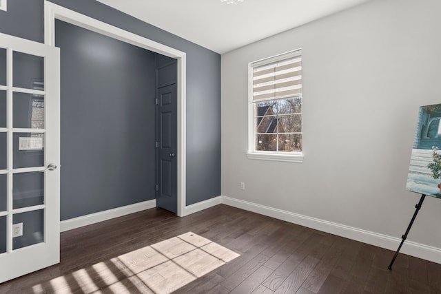 unfurnished bedroom with dark wood-style floors and baseboards