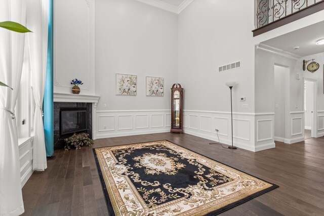 interior space featuring crown molding, visible vents, dark wood finished floors, and a premium fireplace