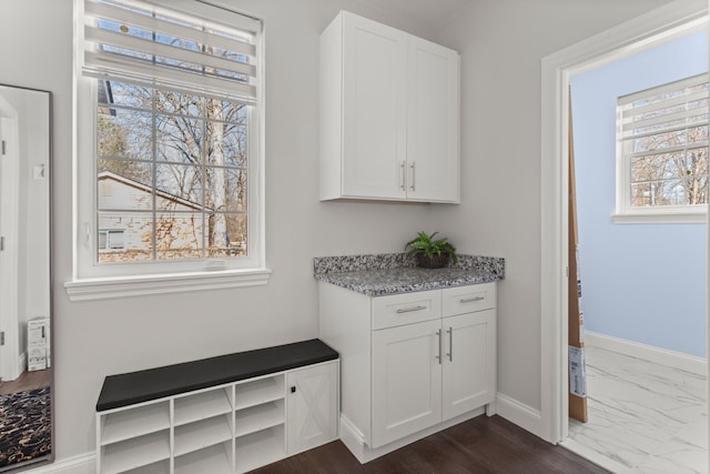 interior space featuring marble finish floor and baseboards