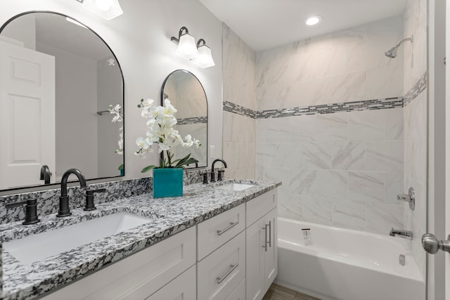 full bath with double vanity, a sink, and bathing tub / shower combination