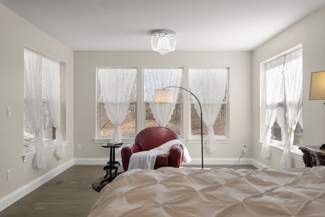 bedroom featuring a chandelier, baseboards, and wood finished floors