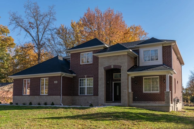 traditional home featuring stone siding, a shingled roof, a front lawn, and brick siding