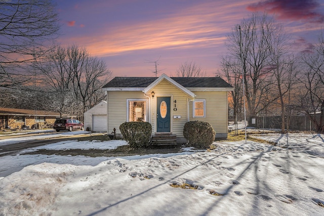 bungalow with driveway, an outdoor structure, and fence