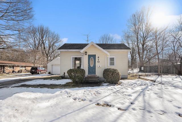 bungalow featuring a garage and fence