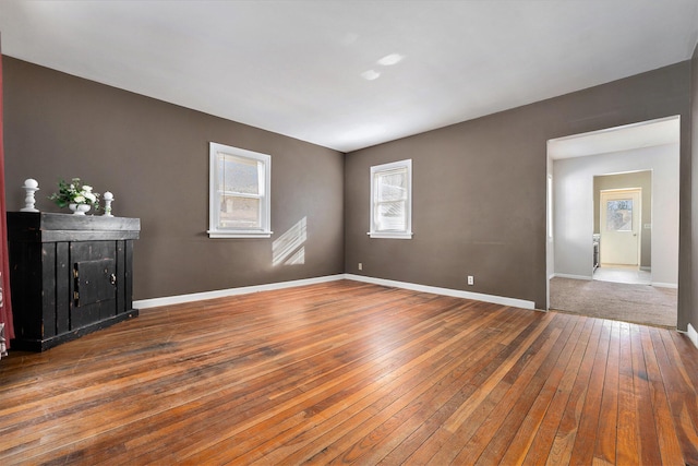 empty room with wood-type flooring and baseboards