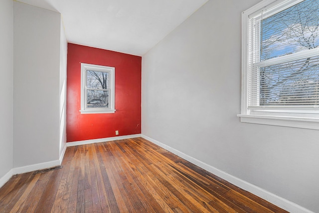 spare room with hardwood / wood-style floors and baseboards