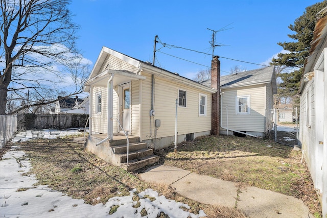 exterior space featuring a chimney and fence