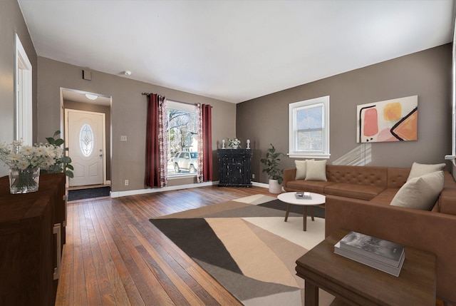 living area with dark wood-type flooring and baseboards