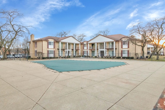 community pool featuring a residential view and fence