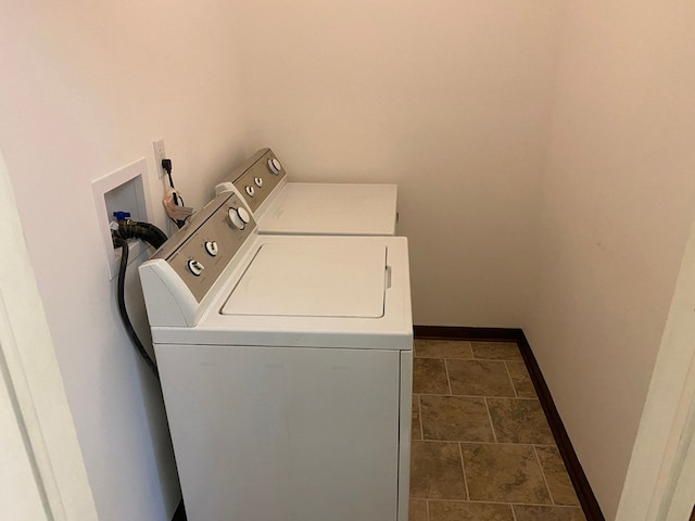 clothes washing area with washing machine and dryer, laundry area, and baseboards