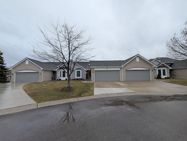 single story home with a garage, brick siding, concrete driveway, and a front yard