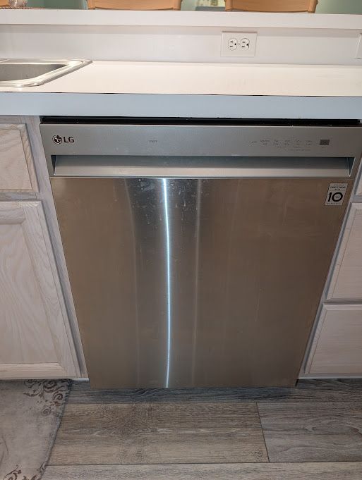 interior details featuring a sink, stainless steel dishwasher, and wood finished floors