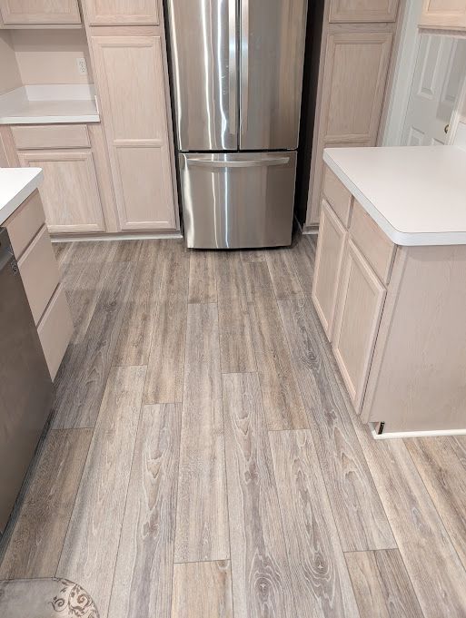 kitchen featuring light countertops, light wood-style flooring, and freestanding refrigerator