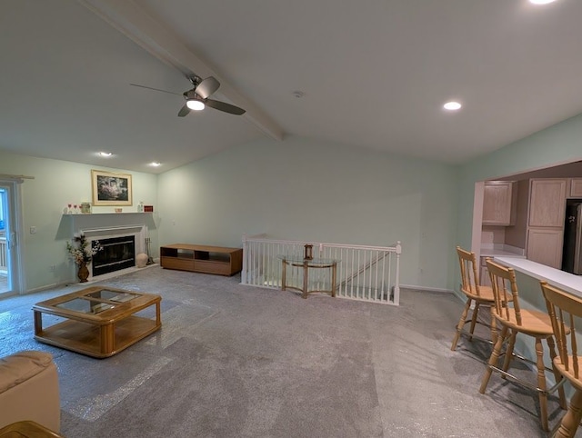 carpeted living area with a glass covered fireplace, lofted ceiling with beams, baseboards, and recessed lighting