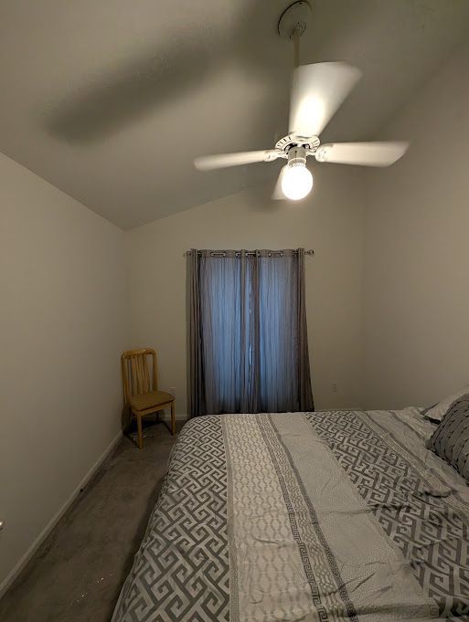 bedroom featuring a ceiling fan, carpet flooring, vaulted ceiling, and baseboards