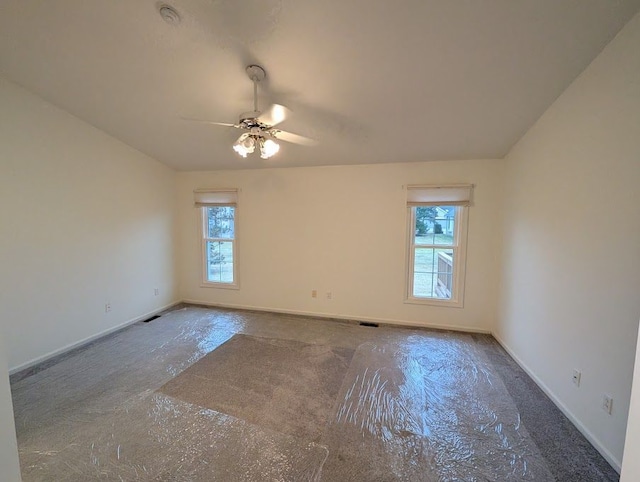 spare room featuring a ceiling fan, a healthy amount of sunlight, and baseboards