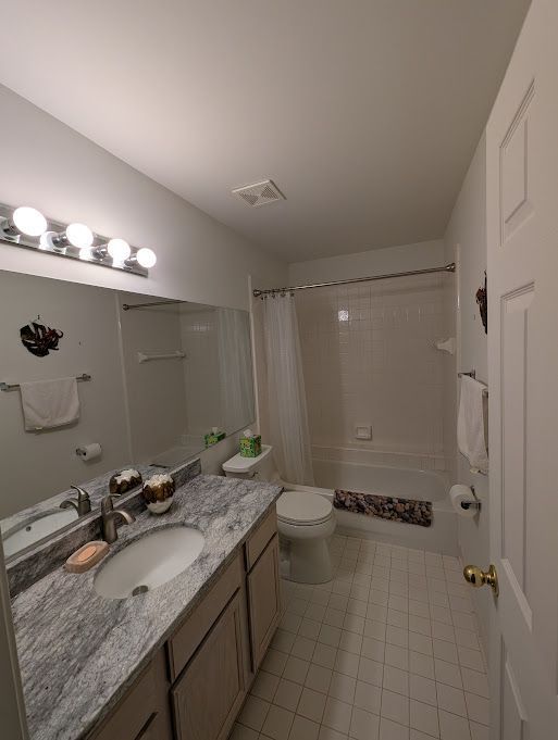 full bath with shower / bath combination with curtain, visible vents, toilet, vanity, and tile patterned flooring