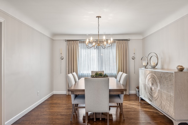 dining room featuring dark wood-type flooring, a notable chandelier, and baseboards