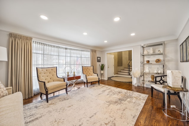 sitting room with dark wood-style floors, crown molding, stairway, and recessed lighting