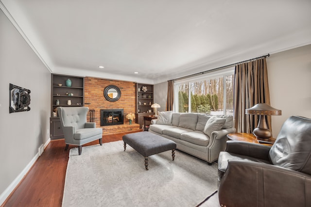 living area with built in features, a fireplace, recessed lighting, wood finished floors, and baseboards